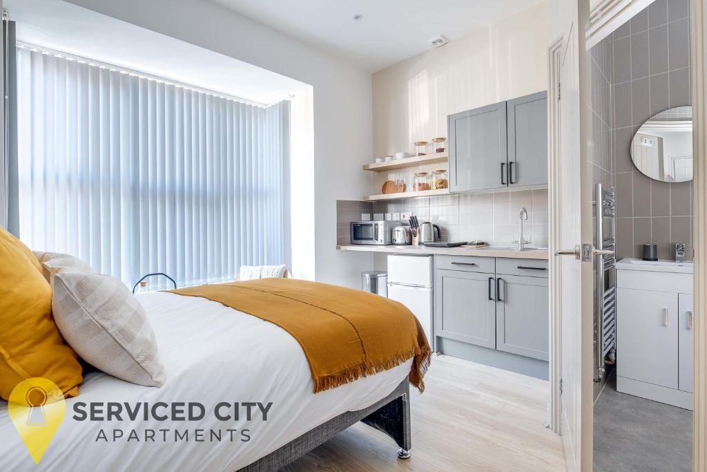 a bedroom with a bed and a small kitchen at SCA - Best Located Studio - CR1 in Birmingham