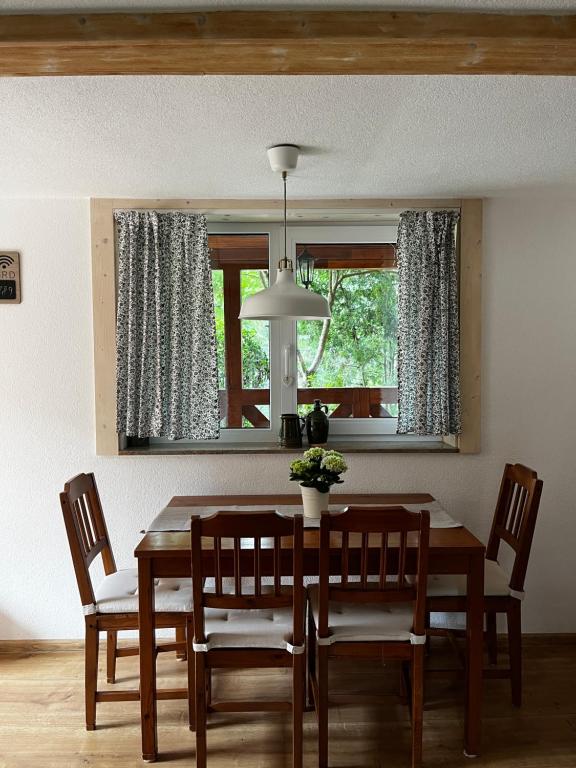 a dining room with a table and chairs and a window at Domček pri vode in Mlynčeky