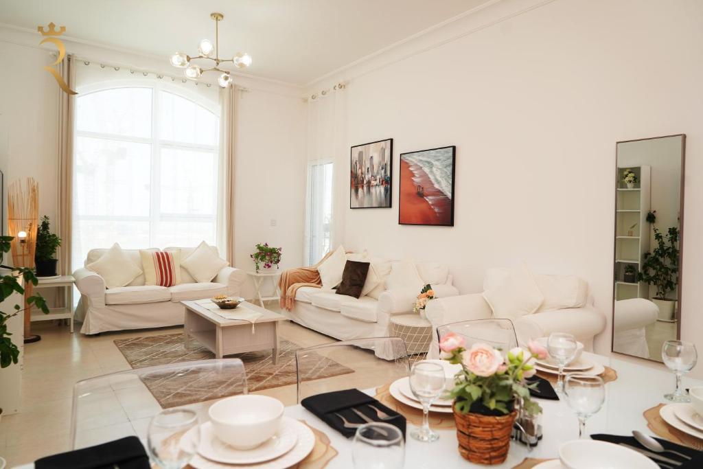 uma sala de estar com mobiliário branco e uma grande janela em An Exclusive 2BR Retreat Experience Yas Island Bliss em Abu Dhabi