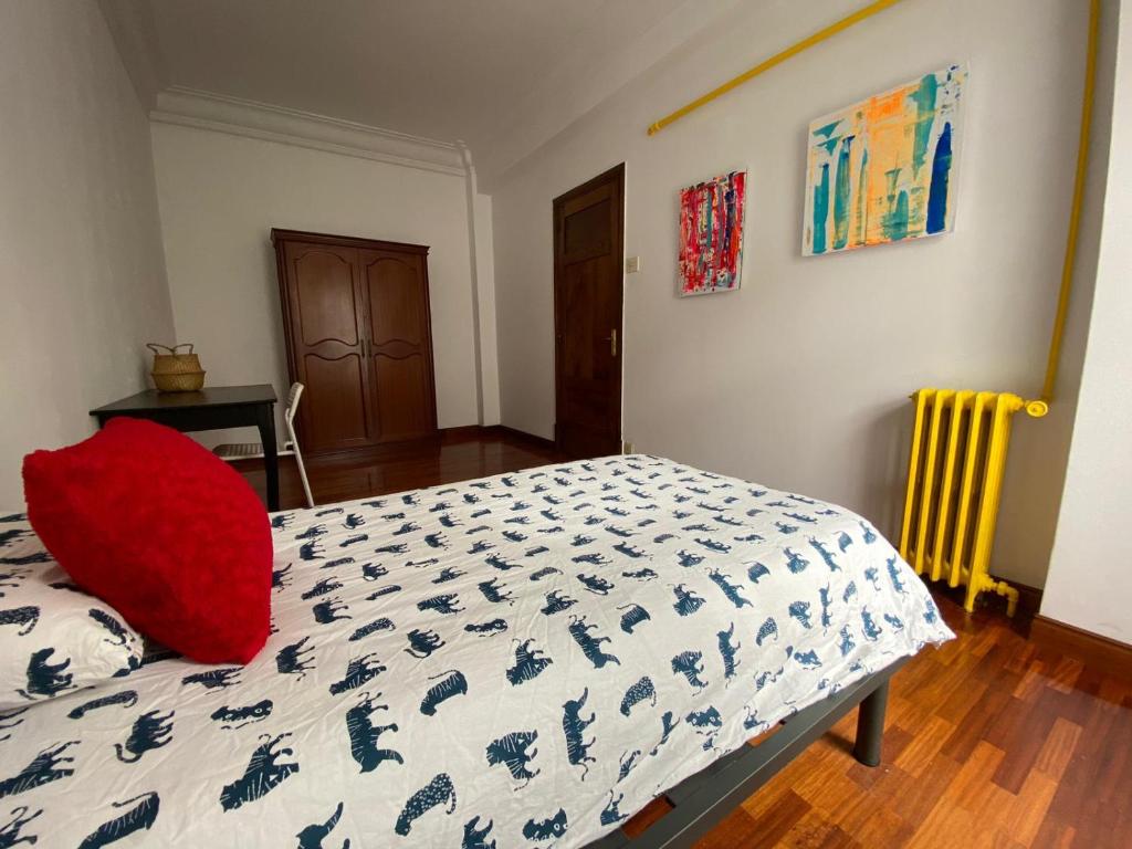 Un dormitorio con una cama con una almohada roja. en Habitación individual Juan florez A Coruña en A Coruña