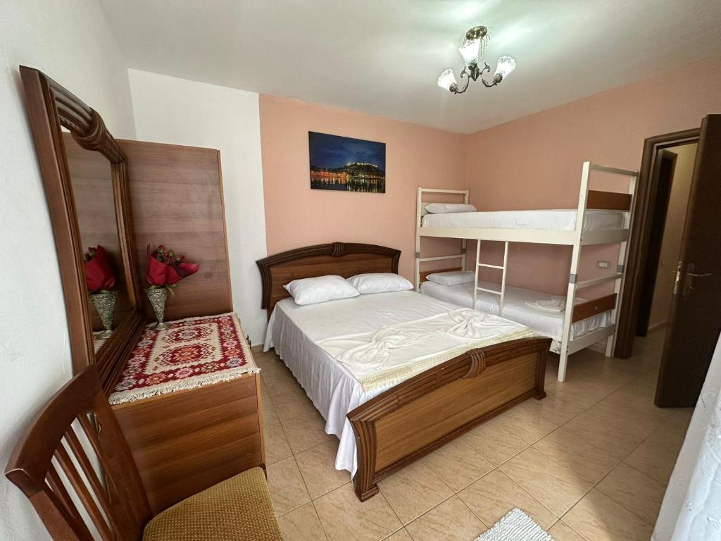 een slaapkamer met een bed, een stapelbed en een bureau bij Cozy apartment in the City Center in Shkodër