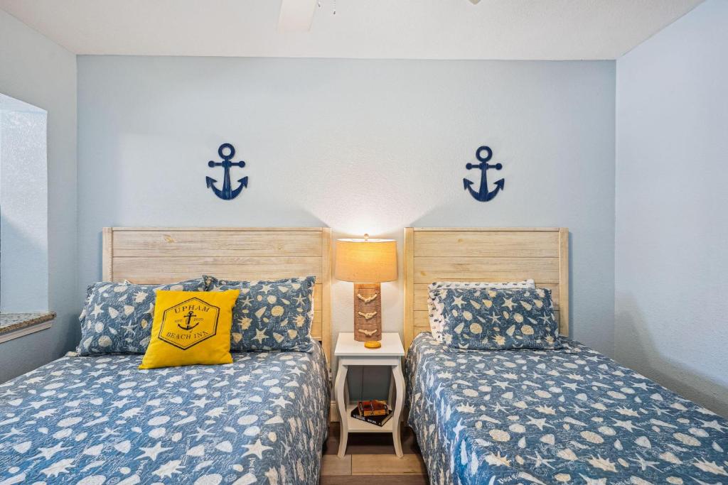 two beds in a room with anchors on the wall at Upham Beach Inn - #3 Studio in St. Pete Beach