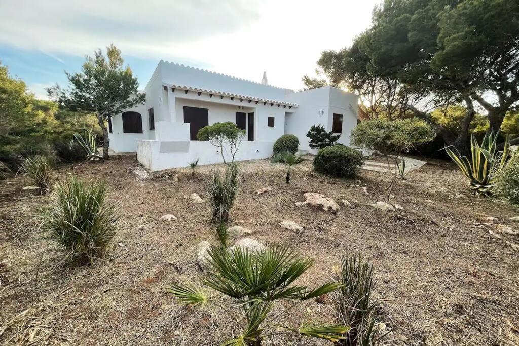 una casa blanca en medio de un campo en Villa Menorquina en playa, en Cala Morell