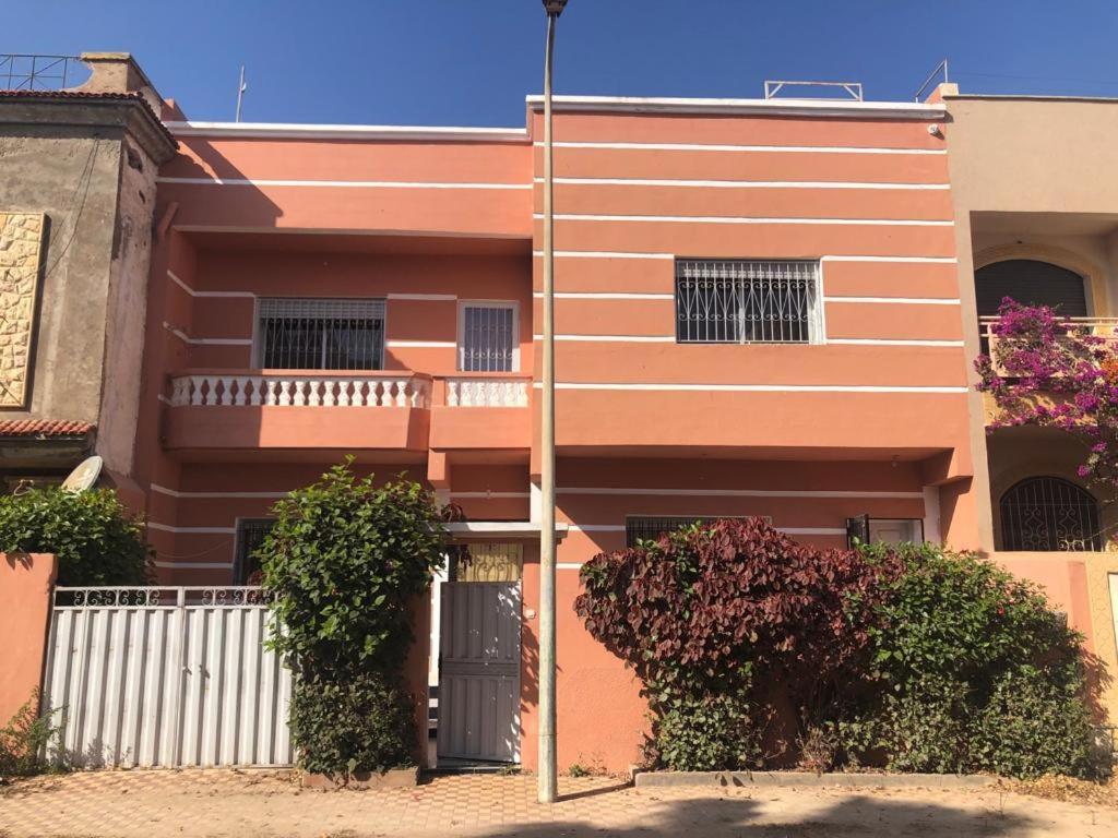 Douar Ourlali的住宿－Villa，一座橙色的建筑,前面有门和灌木