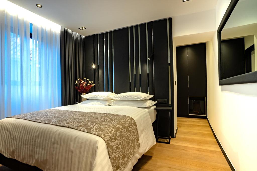 a bedroom with a large bed and a television at City Premium Heritage in Zadar