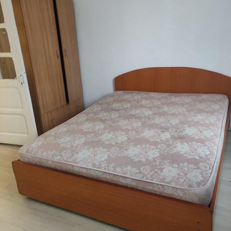 uma pequena cama num quarto com uma estrutura em madeira em Adriana 