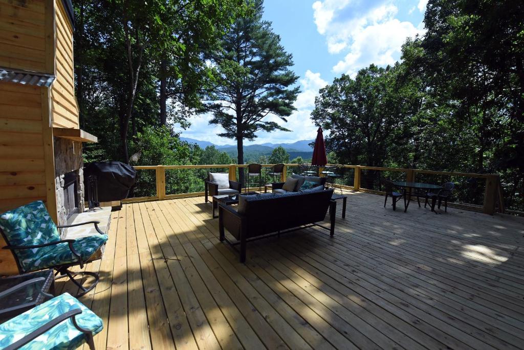 una terraza con sofás y sillas en una casa en Big Pine - Long range mountain views, large decks, hot tub, fire pit and dog friendly!, en Blairsville