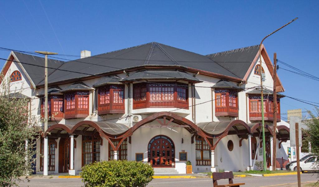 a large white building with a black roof at Grand Hotel - Sierra De La Ventana in Sierra de la Ventana