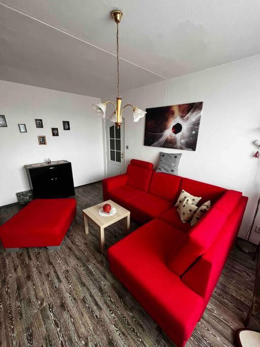 a living room with a red couch and a tv at Ubytování na festival Brutal Assaut in Jaroměř