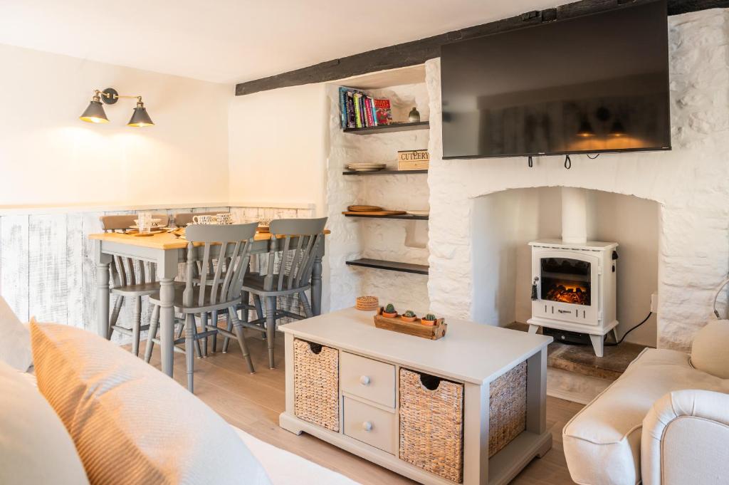 a living room with a couch and a fireplace at 2 Candlemas Cottage in Bourton on the Water