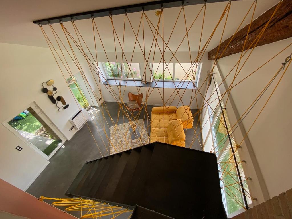 uma vista superior de uma sala de estar com uma escada em Le Préau : charmante maison au bord de l’Isère em Bourg-de-Péage