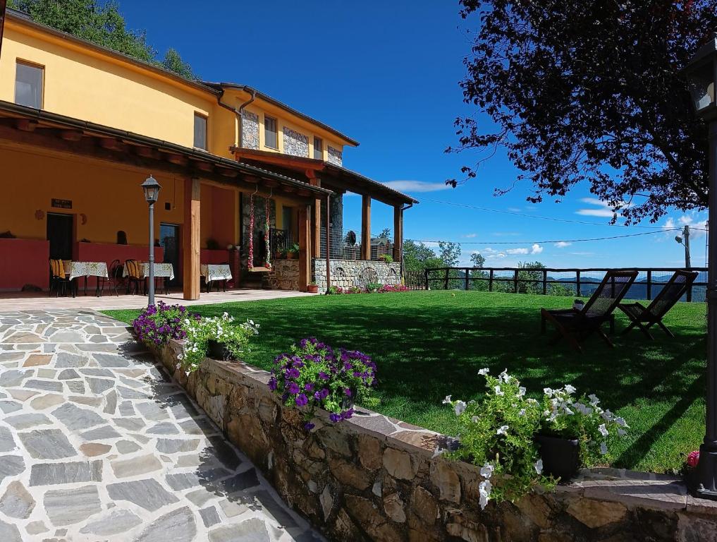 una casa con un muro di pietra e alcuni fiori di Terra Del Bosco Agriturismo a Sesta Godano