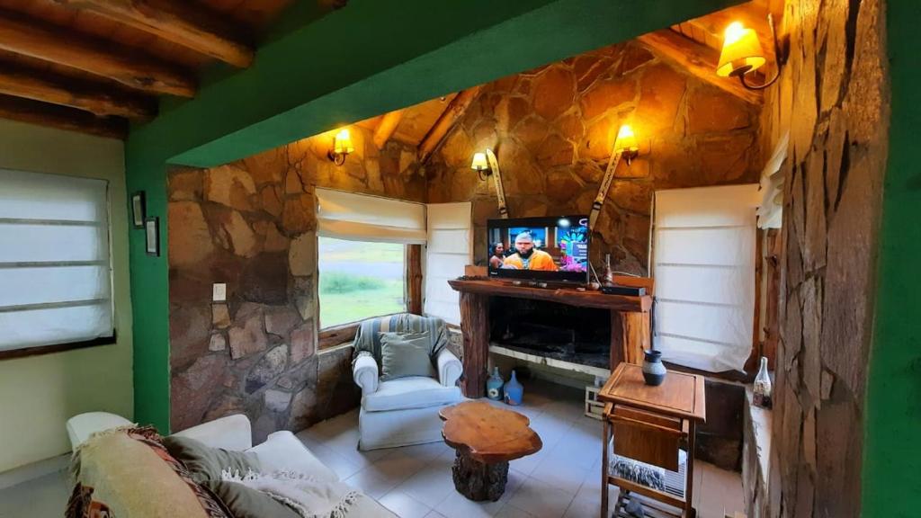 a living room with a stone wall and a tv at Antu in Caviahue
