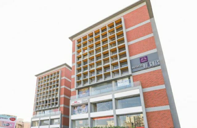 a building with two tall buildings in a city at Hotel Prime Villa Gurukul in Ahmedabad