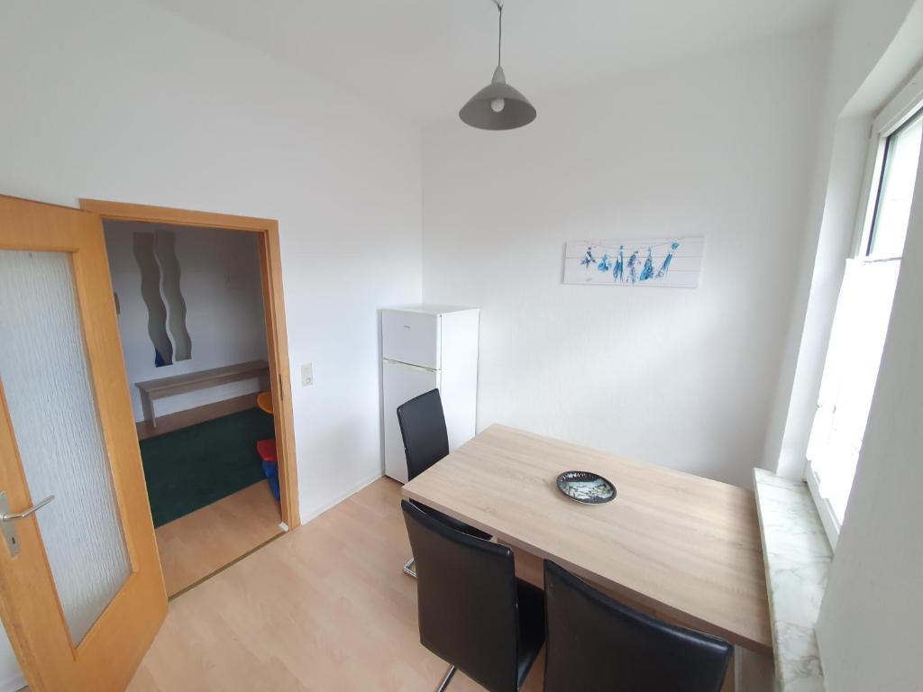 ブラウンラーゲにあるMikes Fewoの木製のテーブルと椅子が備わる小さな客室です。