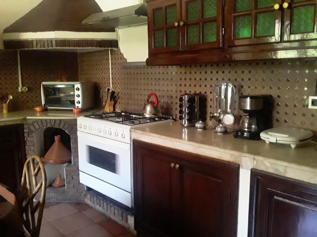 a kitchen with a white stove and a microwave at Villa a Marrakech in Marrakesh