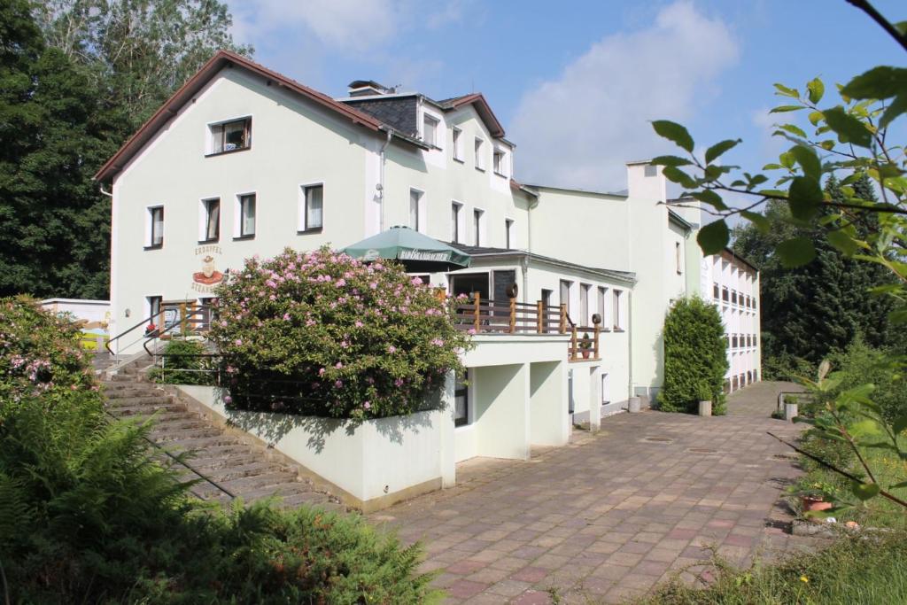 an exterior view of a white house with a courtyard at Hotel Carolaruh in Bad Elster