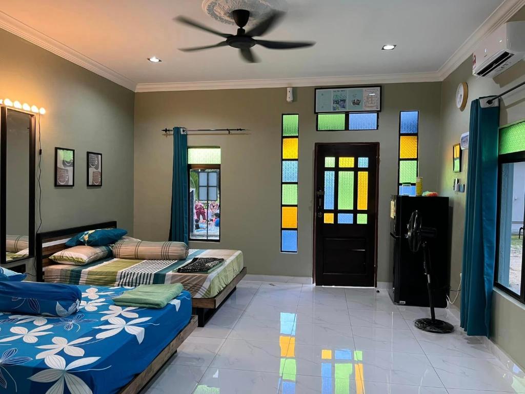 a bedroom with two beds and a ceiling fan at Rumah Armand Studio Family Suite with Swimming Pool Pengkalan Balak Tg Bidara Masjid Tanah Melaka 