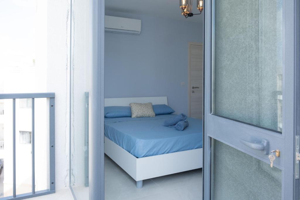 a small bedroom with a bed and a glass door at Side-seaview apartment near beach and close to St. Julians in Baħar iċ-Ċagħaq