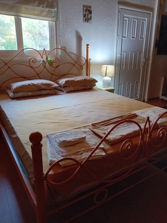 a large bed with a wooden headboard in a bedroom at Vasiliki in Dhílesi