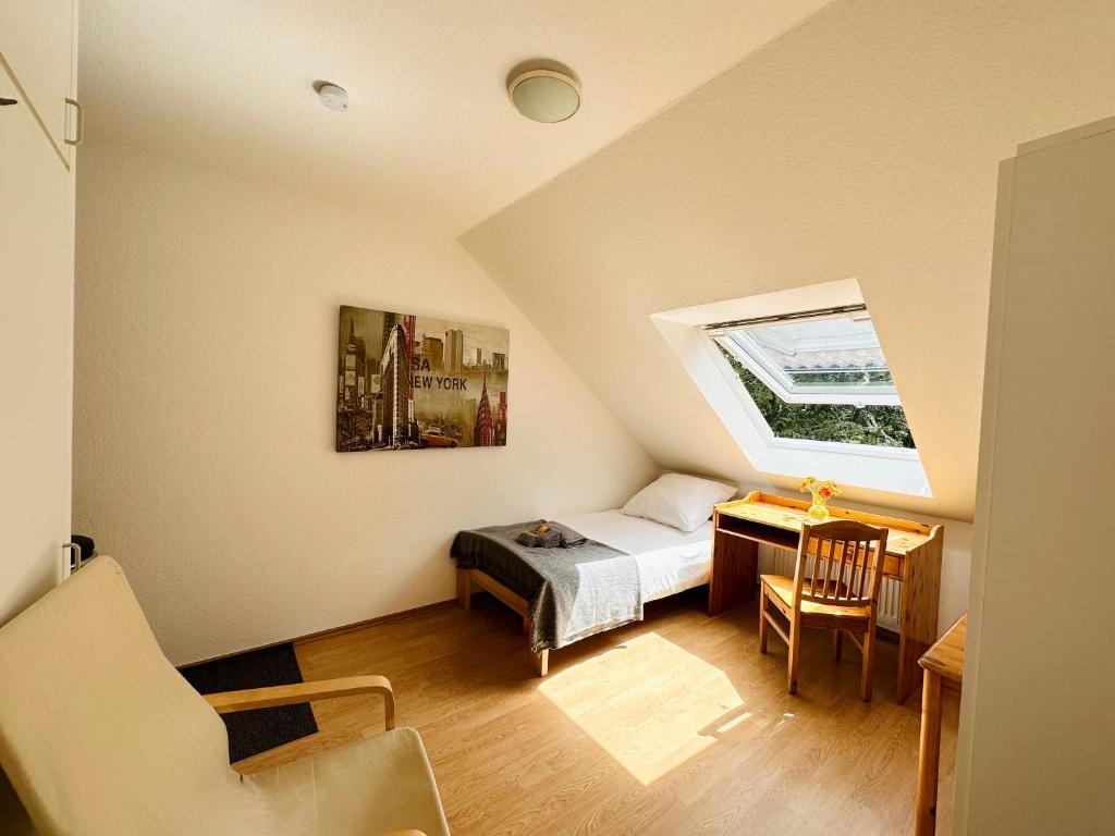 a bedroom with a bed and a desk and a window at Möbliertes Apartment-Nahe Zeche Zollverein- in Essen