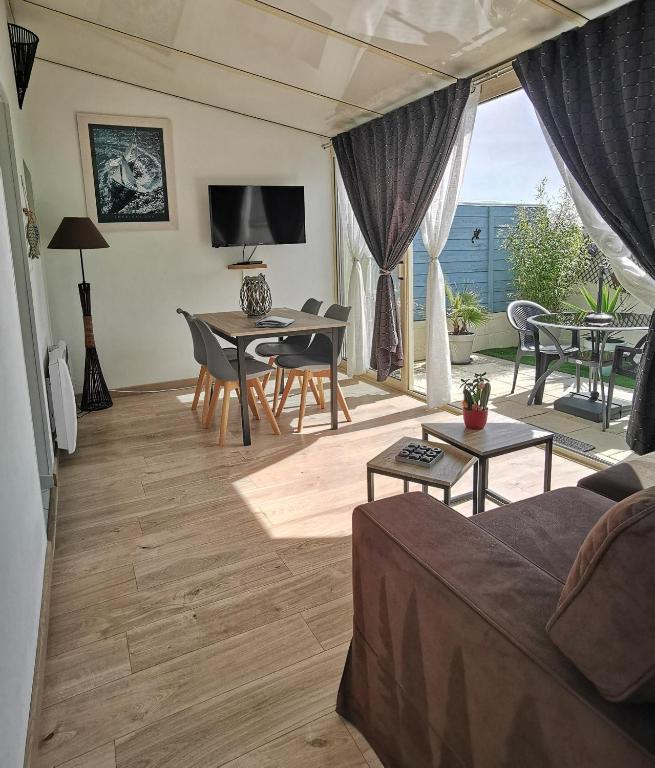 ein Wohnzimmer mit einem Sofa und einem Tisch in der Unterkunft Escapade charentaise in Aigrefeuille-dʼAunis