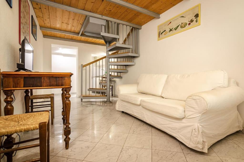 een woonkamer met een witte bank en een piano bij Fossalta Lodge in Bologna