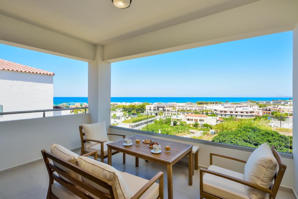 balcón con mesa, sillas y vistas al océano en Panthea Luxury Living en Kolymvari
