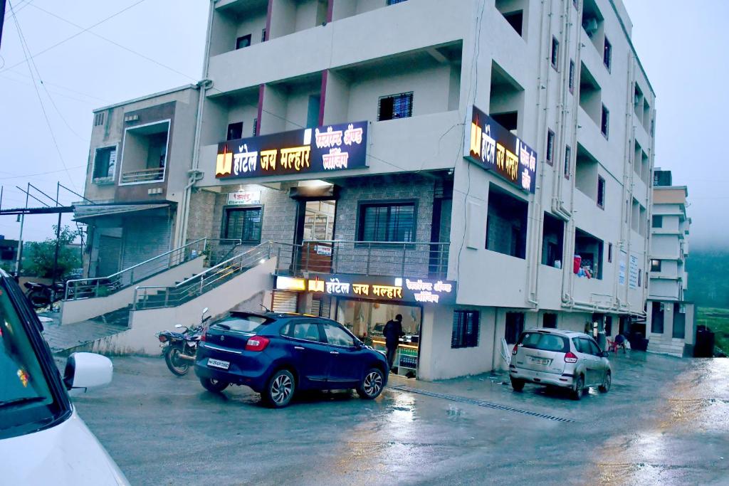 une voiture bleue garée devant un bâtiment dans l'établissement Hotel jay malhar and lodging, à Igatpuri