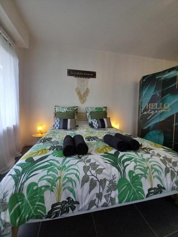 Schlafzimmer mit einem Bett mit einer grünen und weißen Bettdecke in der Unterkunft Cocon reposant à 5 min du centre d'Angoulême in Angoulême