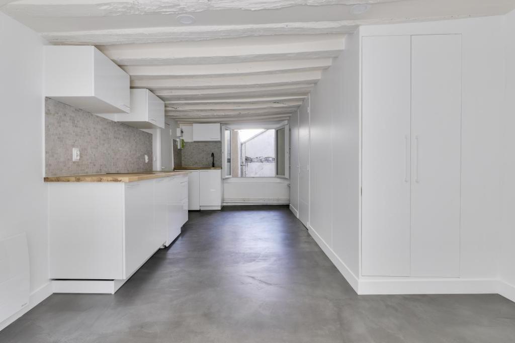 Habitación vacía con paredes blancas y techo. en Heart of Paris Apartment en París