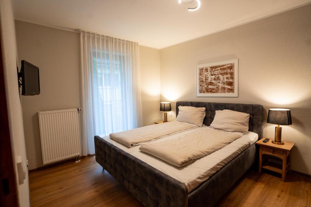 Un dormitorio con una cama grande y una ventana en Boardinghouse CityHome am Kurpark en Bad Salzuflen