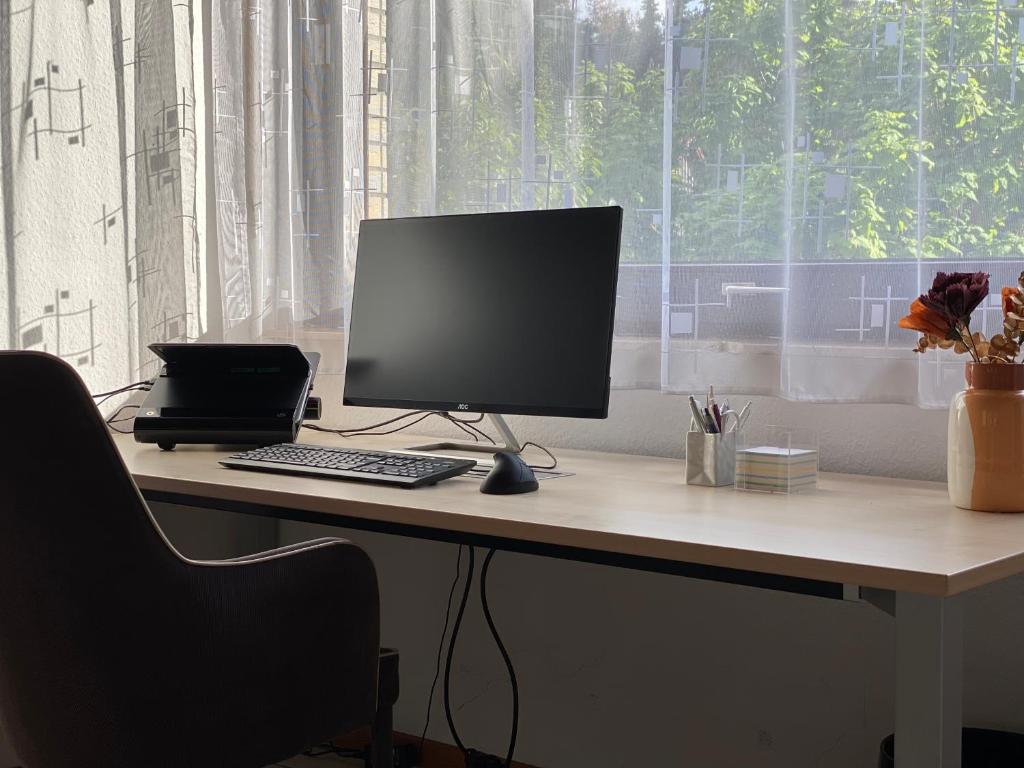 escritorio con monitor de ordenador y ordenador portátil en Appartement, en Burgdorf