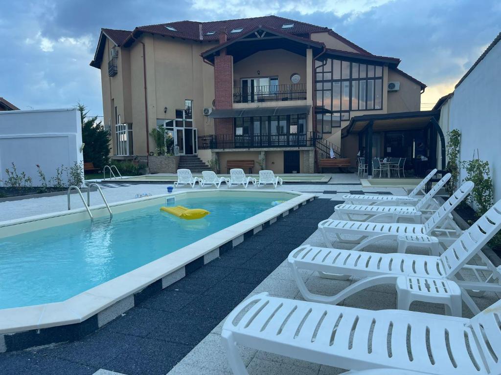 百樂費利克斯的住宿－Thermal Family Resort，一个带躺椅的游泳池以及一间房屋