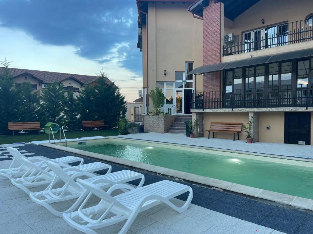a group of lounge chairs sitting next to a swimming pool at Thermal Family Resort in Baile Felix