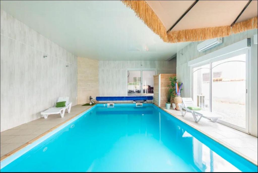 ein großer Pool in einem Zimmer mit einem großen Fenster in der Unterkunft villa grand mère marie in Brazey-en-Plaine