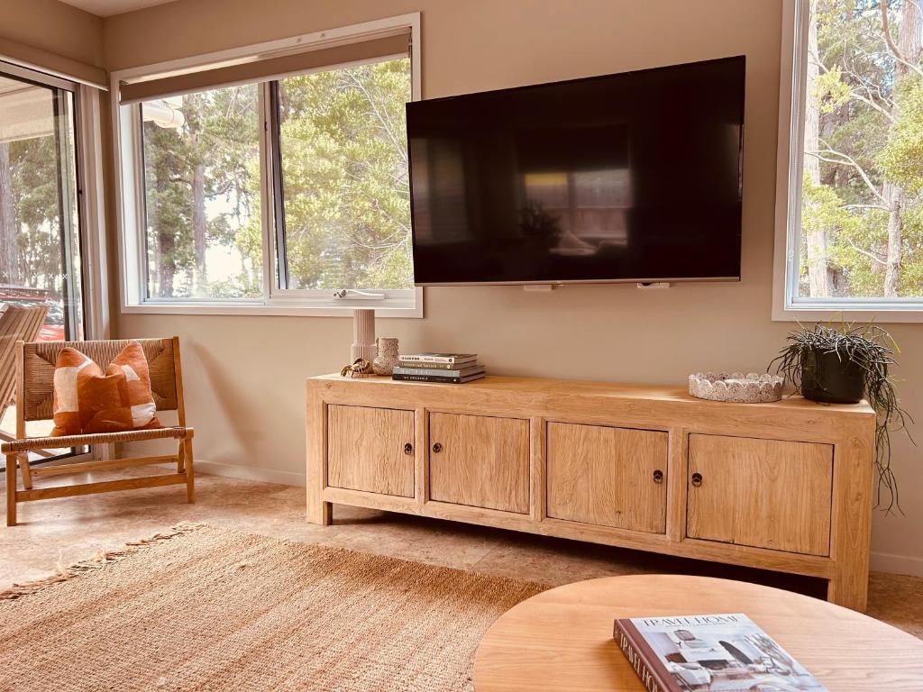 a living room with a large flat screen tv on the wall at Adventure Bay Holiday Home in Adventure Bay