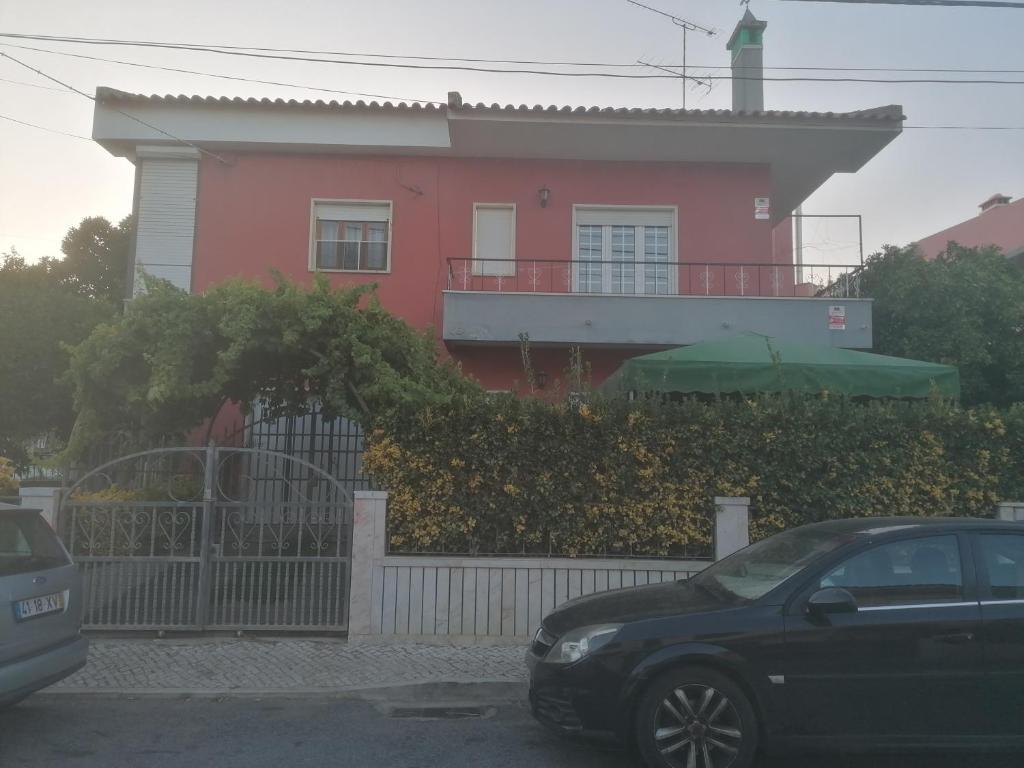 een roze huis met een auto ervoor geparkeerd bij River City House 