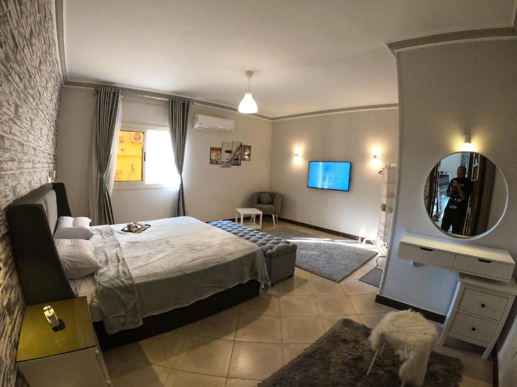 カイロにあるLuxury & spacious 3BD Apartment in family houseのベッドと鏡が備わるホテルルーム