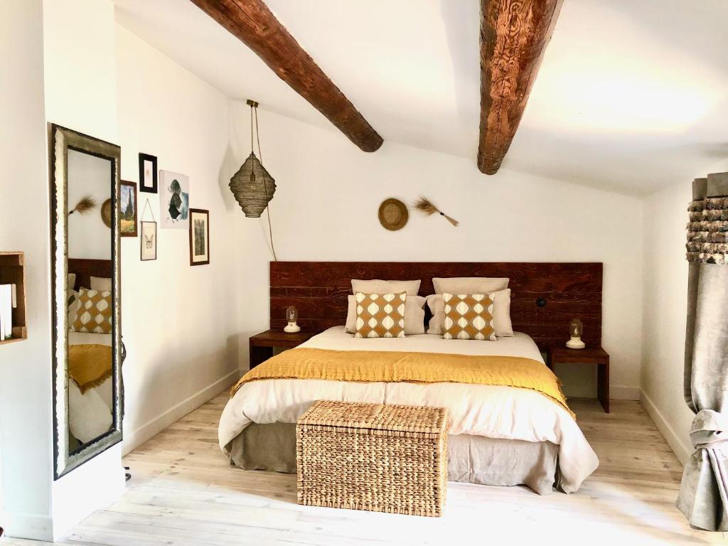 - une chambre avec un grand lit et une tête de lit en bois dans l'établissement Holiday home L'Autre Maison, à Saint-Jean-de-Ceyrargues