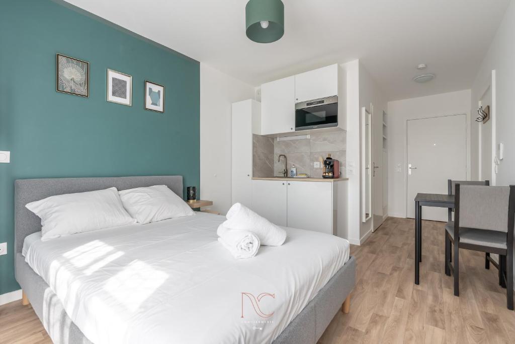 a bedroom with a white bed and a dining room at *Disneyland-Paris* 2pers Wifi, Parking, Netflix in Serris