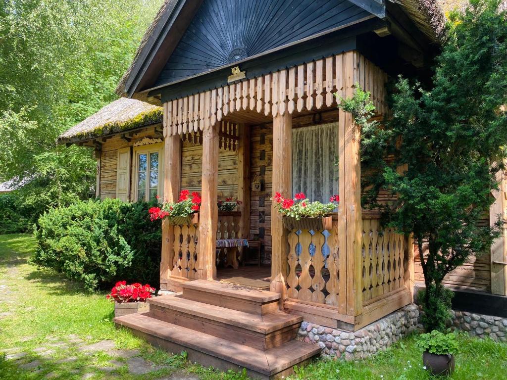 a wooden gazebo with a porch and flowers at Koronkowa Chata in Michalin