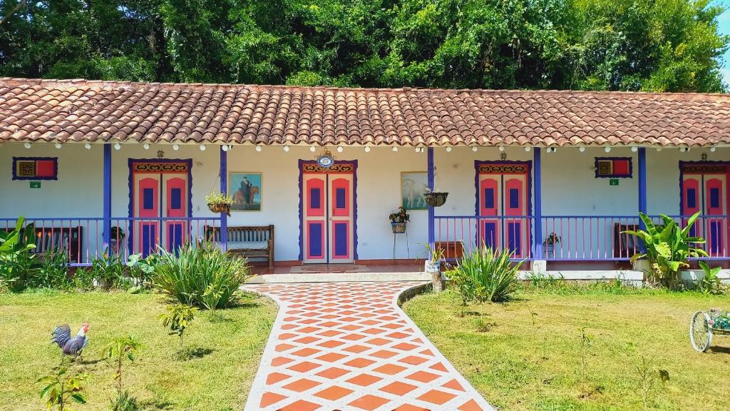 a house with colorful doors and a brick path at Finca Hotel Villa Del Sol in Pueblo Tapao