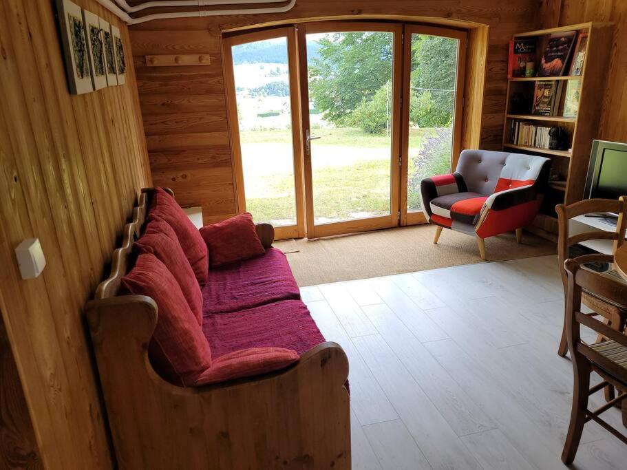 sala de estar con sofá y silla en Bel appartement rez-de-jardin en Saint-Genest-Malifaux