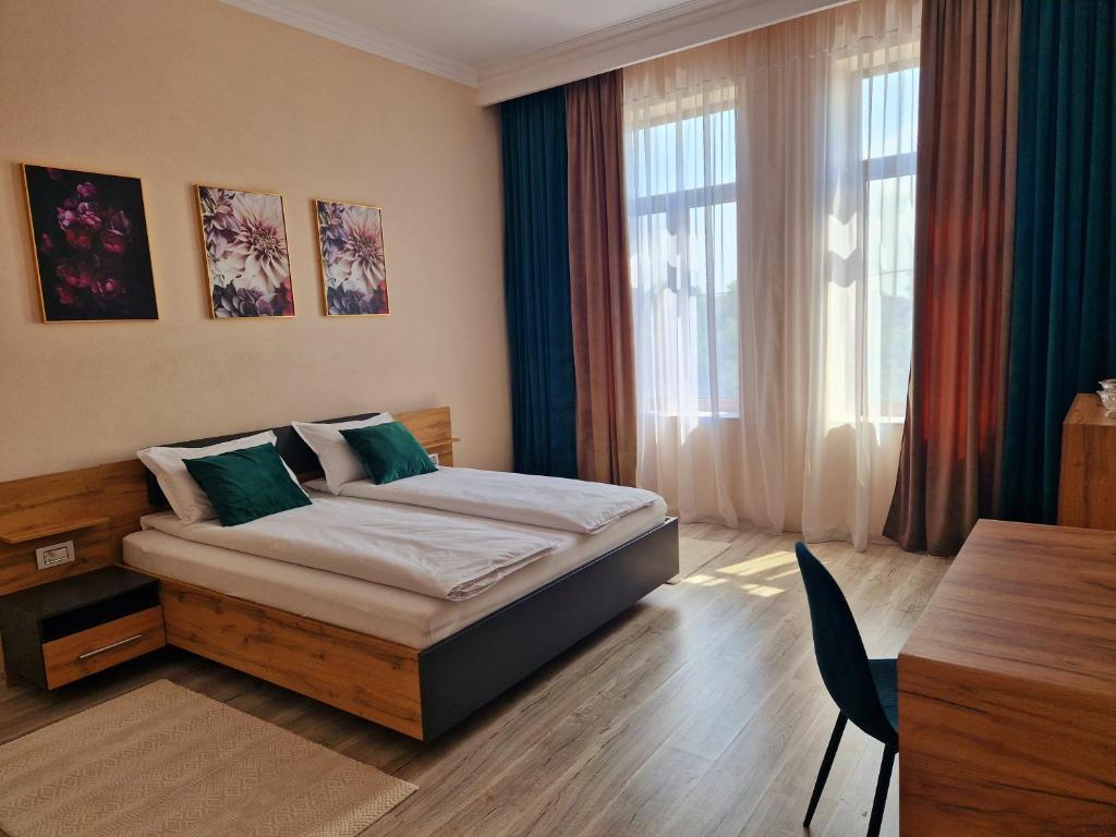 a bedroom with a bed with a desk and a table at ORI Family Apart. Malul Muresului in Arad