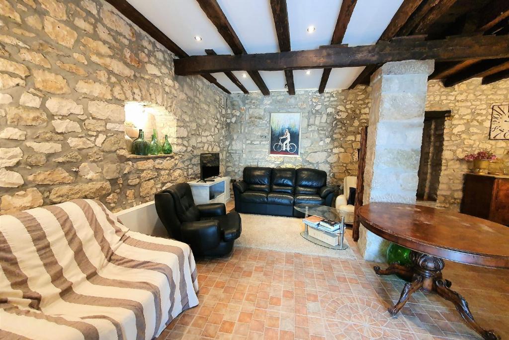 a living room with leather furniture and a stone wall at Comfortable stone house apartment 4 persons Poreč, 4km in Musalez