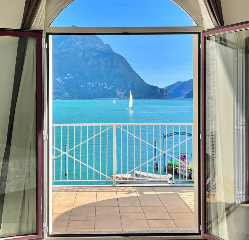 una ventana con vistas al agua y a un velero en Hotel Lovere Resort & Spa en Lovere