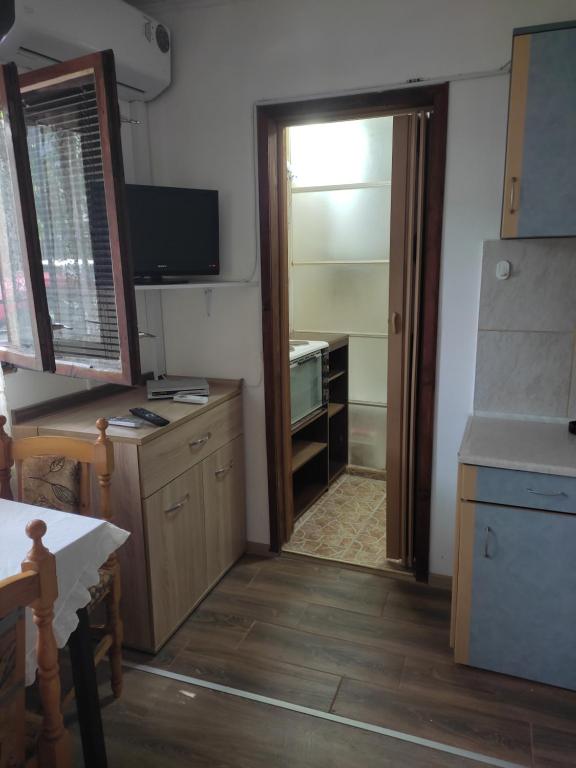 a kitchen with a door open to a room with a desk at Уют и топлина. in Varna City