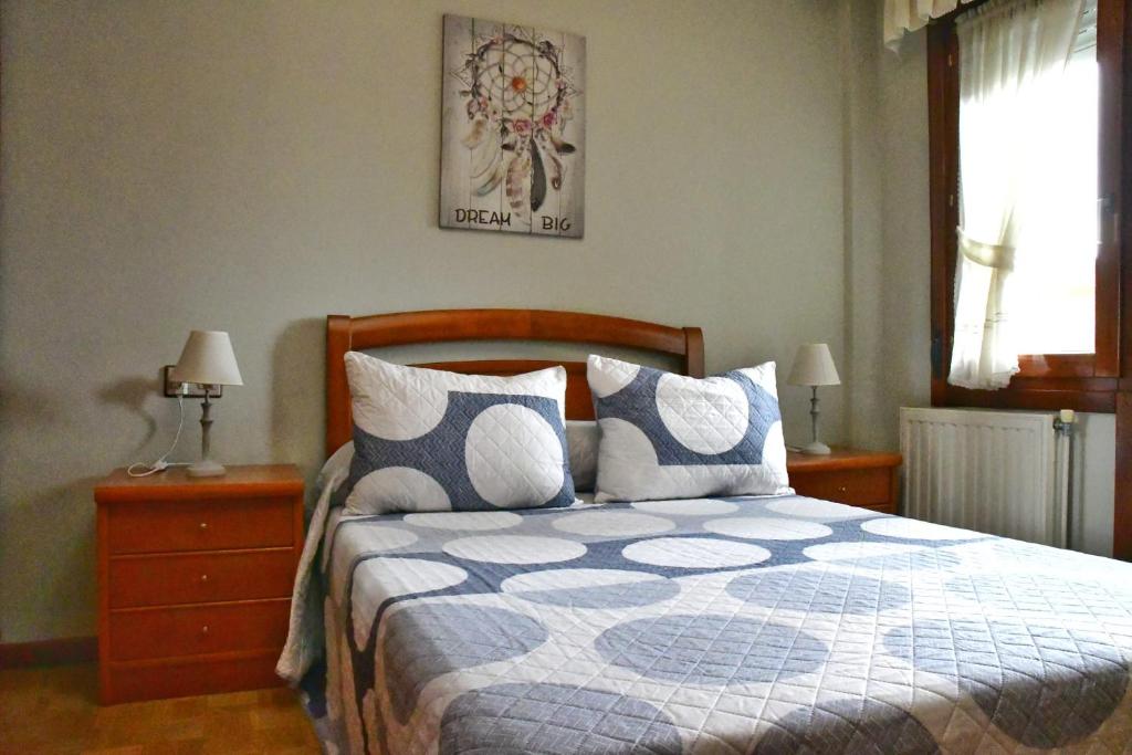 1 dormitorio con 1 cama con edredón azul y blanco en Puerta la Villa en Avilés