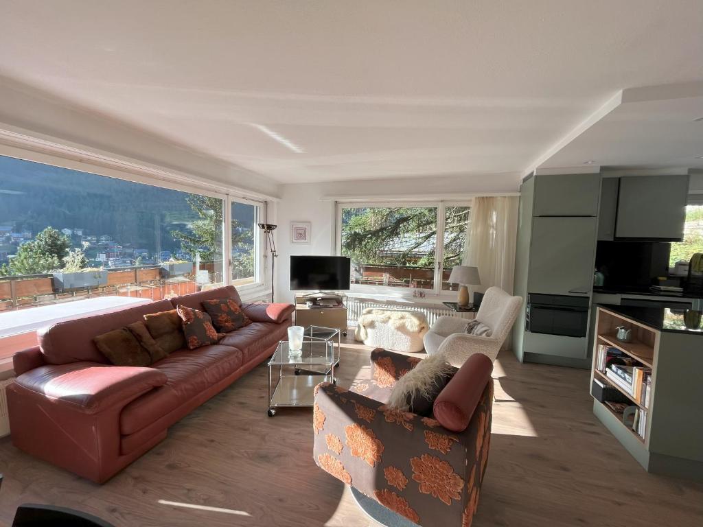 ツェルマットにあるZermatt Panoramic View Flatのリビングルーム(ソファ付)、大きな窓が備わります。